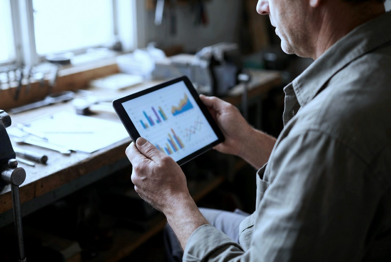 Hände eines Handwerkers mit Tablet in einer Werkstatt