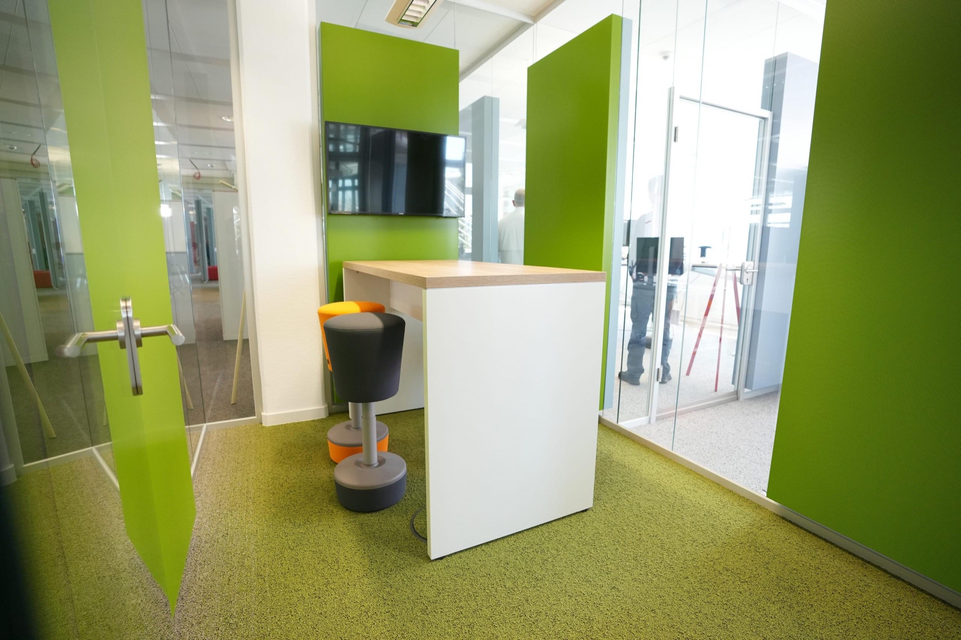 Huddle-Raum mit Stehtisch und Bildschirm