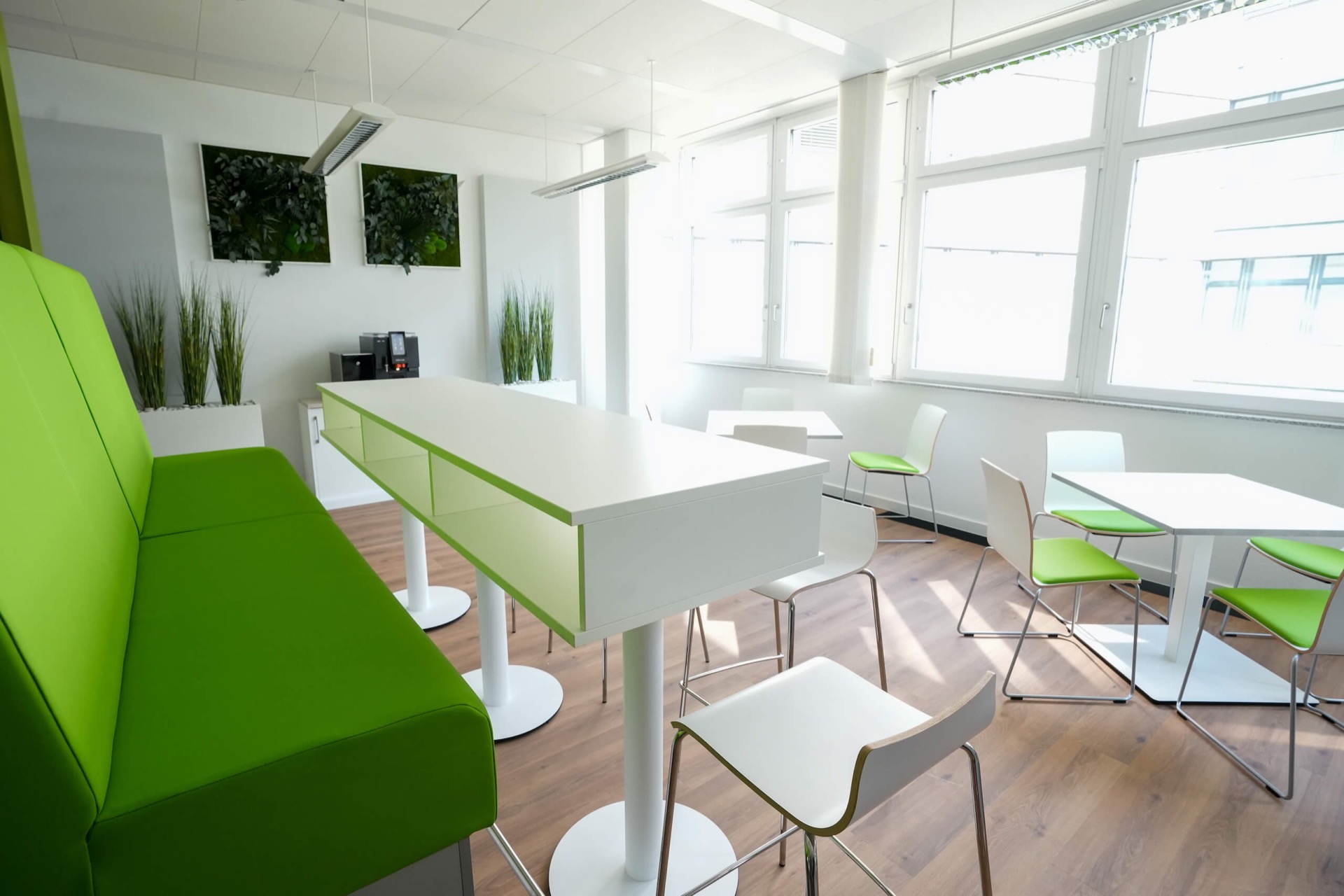 Kantine mit grüner Sitzbank und Stehtischen